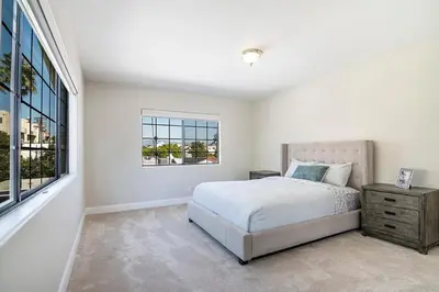 a white bedroom with a bed and a window at Beautiful 6BR Family 2-Story Villa With Large Backyard and Outdoor Kitchen in Los Angeles