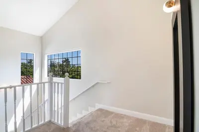 a white staircase in a house with a window at Beautiful 6BR Family 2-Story Villa With Large Backyard and Outdoor Kitchen in Los Angeles