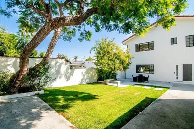 a backyard with a tree and a white building at Beautiful 6BR Family 2-Story Villa With Large Backyard and Outdoor Kitchen in Los Angeles