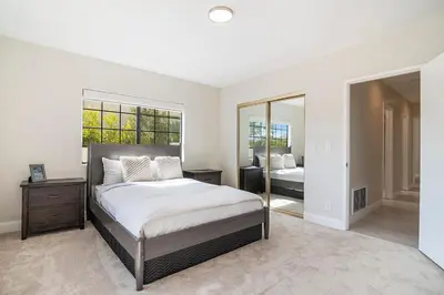 a white bedroom with a bed and a mirror at Beautiful 6BR Family 2-Story Villa With Large Backyard and Outdoor Kitchen in Los Angeles