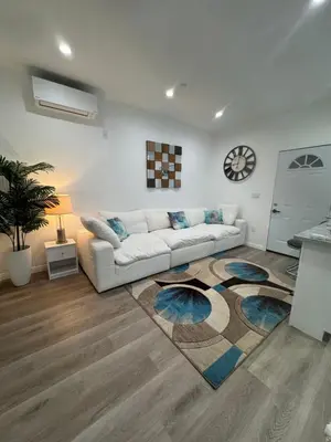 a living room with a white couch and a rug at Luxury mini house in Hughes-Canoga Park Heliport