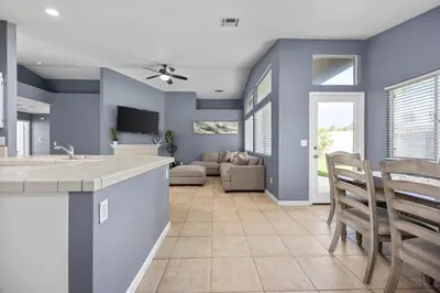 a kitchen and living room with blue walls at 3 Bed 2 Bath Newly Furnished - Available Now in Bakersfield