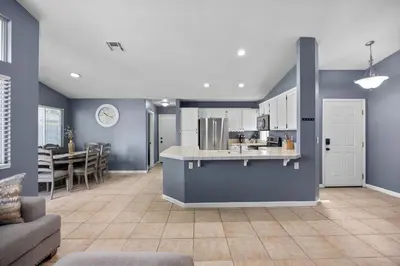 a kitchen and living room with blue walls at 3 Bed 2 Bath Newly Furnished - Available Now in Bakersfield
