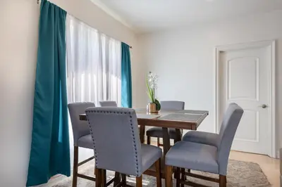 a dining room with a wooden table and chairs at Spacious 2BR Apartment with Full Kitchen & Dining In Beverly Hills in Los Angeles