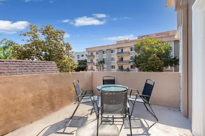 a patio with a glass table and chairs on a balcony at Spacious 2BR Apartment with Full Kitchen & Dining In Beverly Hills in Los Angeles