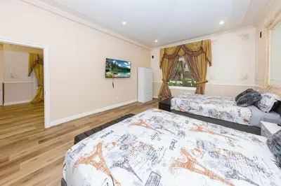 a bedroom with two beds and a tv on the wall at Spacious 2BR with Kitchenette and Dining in Beverly Hills in Los Angeles