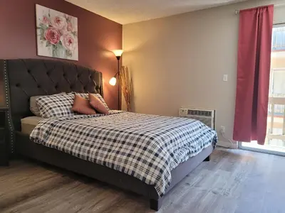 a bedroom with a bed with a checkered blanket at Beverly Hills Suite in Los Angeles