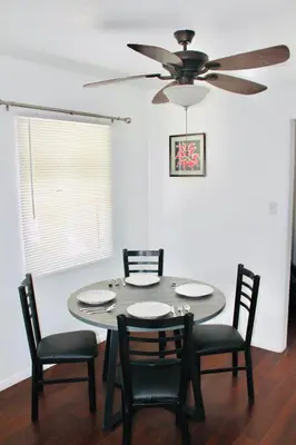 a dining room table with chairs and a ceiling fan at Los Angeles Red Rose in Monterey Park