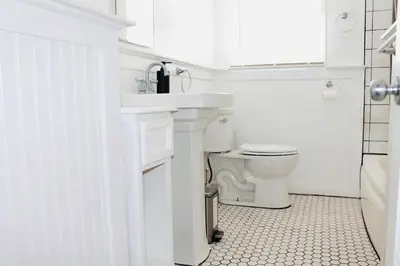 a white bathroom with a toilet and a sink at Los Angeles Red Rose in Monterey Park