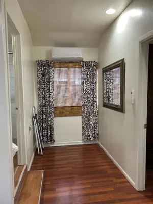 a living room with a window and wooden floors at Jacob Unit-C in Hawthorne