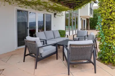 a patio with a table and chairs and windows at 2 Mi to Promenade at Westlake Mtn-View Haven! in Westlake Village