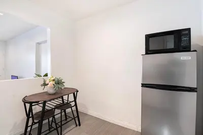 a small table with a microwave on top of a refrigerator at Ground-Floor 1-Bedroom by Beverly Hills Steps from Restaurants, Cafes and Shopping in Los Angeles