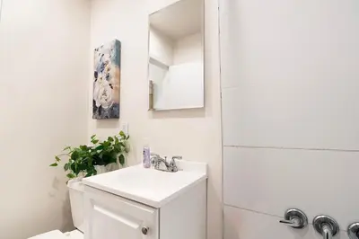 a white bathroom with a sink and a mirror at Ground-Floor 1-Bedroom by Beverly Hills Steps from Restaurants, Cafes and Shopping in Los Angeles