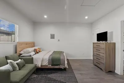 a bedroom with a bed and a couch and a television at Charming Valley Village Studio Retreat in Los Angeles