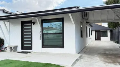 a white house with black doors and a driveway at Modern Studio Stylish &Cozy Right Unit in Los Angeles