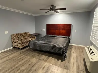 a bedroom with a bed and a chair at Dutch Motel in Loma Linda