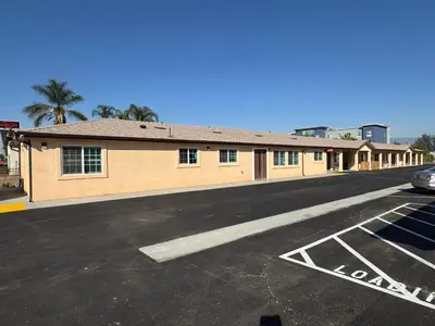 an empty parking lot in front of a building at Dutch Motel in Loma Linda