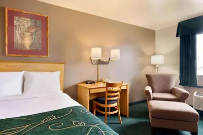 a hotel room with a bed and a desk and a chair at Travelodge by Wyndham Yermo in Yermo