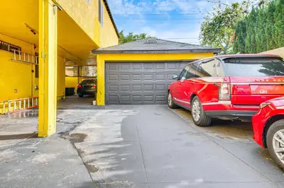 a red car parked in front of a garage at 8 Mi to Dtwn LA Apt with Shared Patio! in Los Angeles