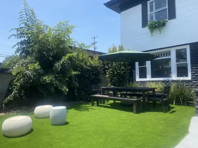 a garden with a picnic table and an umbrella at Burlington Hostel in Los Angeles