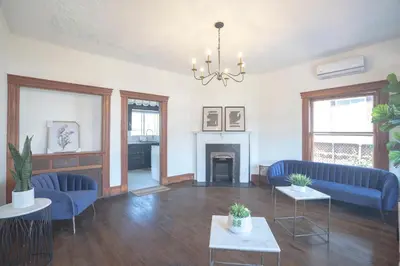 a living room with blue chairs and a fireplace at Burlington Hostel in Los Angeles