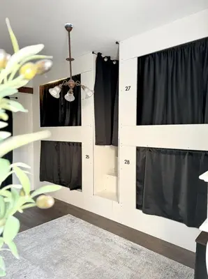 a bedroom with a white bunk bed with black curtains at Burlington Hostel in Los Angeles