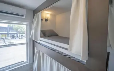 a small bedroom with a bed and a window at Burlington Hostel in Los Angeles