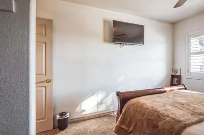 a bedroom with a bed and a flat screen tv on the wall at Peaceful Oasis in Anaheim
