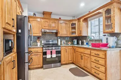 a kitchen with wooden cabinets and a black refrigerator at Peaceful Oasis in Anaheim