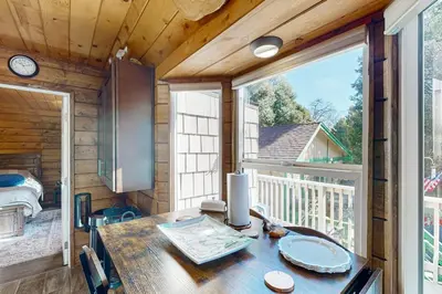 a dining room with a table and a large window at Relaxing Retreat with Deck, 1 Mi to Lake Arrowhead! in Cedar Glen