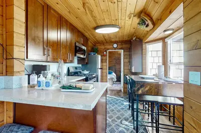 a kitchen with wooden cabinets and a counter top at Relaxing Retreat with Deck, 1 Mi to Lake Arrowhead! in Cedar Glen