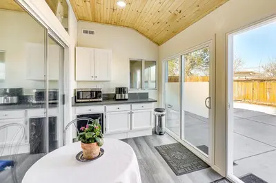 a kitchen with white cabinets and a table with a plant at 10 Mi to Mojave Narrows Victorville Studio in Victorville