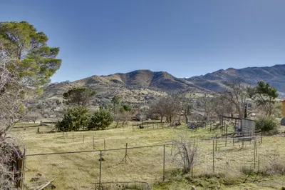 a field with a fence and mountains in the background at Lake and Mountain Views Cozy California Stay in Mountain Mesa