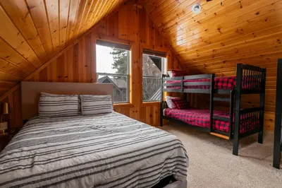 a bedroom with a bed in a wooden cabin at Bear Creek Haven -Nestled between the Village & Lake! in Big Bear Lake