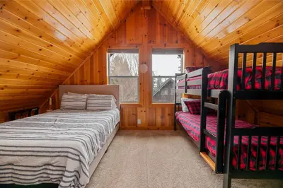 a bedroom with two beds in a wooden cabin at Bear Creek Haven -Nestled between the Village & Lake! in Big Bear Lake