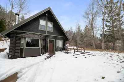 a house with a picnic table in the snow at Bear Creek Haven -Nestled between the Village & Lake! in Big Bear Lake