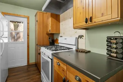 a kitchen with wooden cabinets and a stove top oven at Mountain Xscape - Hot Tub, Fireplace, Deck, Barbeque in Big Bear Lake