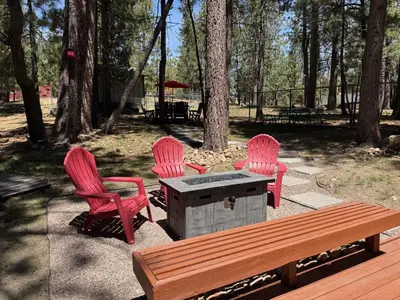 three pink chairs and a table and a bench at Mountain Xscape - Hot Tub, Fireplace, Deck, Barbeque in Big Bear Lake