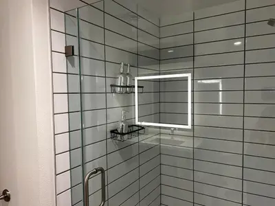 a bathroom with a glass shower with a mirror at Santa Monica Bright Studio with stunning view in Los Angeles