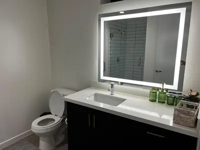 a bathroom with a sink and a toilet with a mirror at Santa Monica Bright Studio with stunning view in Los Angeles