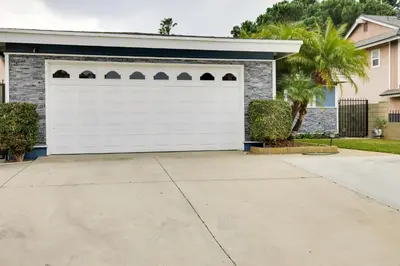 a white garage door in front of a house at 10 Mi to Redondo Beach Carson Home with Pool Table! in Carson