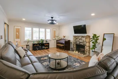 a living room with a leather couch and a fireplace at 10 Mi to Redondo Beach Carson Home with Pool Table! in Carson