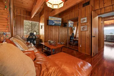 a living room with a leather couch and a table at The Cedar Bear Lodge, Jacuzzi with an Outdoor Patio & BBQ in Big Bear City Airport