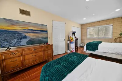 a bedroom with a bed and a large painting on the wall at The Cedar Bear Lodge, Jacuzzi with an Outdoor Patio & BBQ in Big Bear City Airport