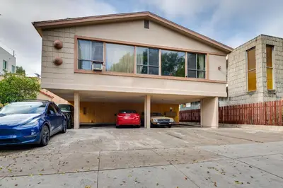 a house with two cars parked in a parking lot at 1 Mi to Dtwn Melrose Cozy Condo with Patio in Los Angeles