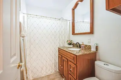 a bathroom with a toilet and a sink and a mirror at Family Oasis in Anaheim
