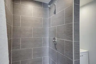 a bathroom with a shower with gray tiles at 6 Mi to Frazier Mountain Cozy Studio Retreat in Frazier Park