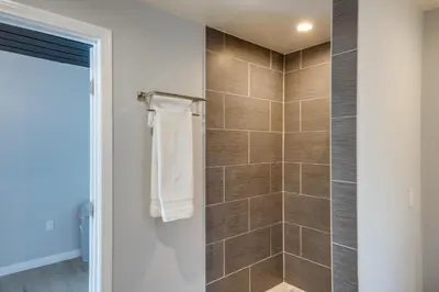 a bathroom with a shower with brown tiles at 6 Mi to Frazier Mountain Cozy Studio Retreat in Frazier Park