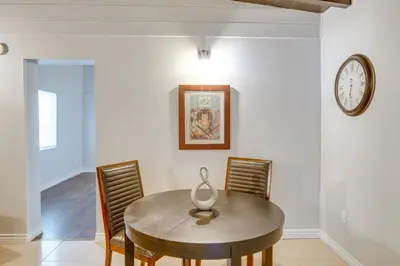 a dining room table with chairs and a clock on the wall at Hike and Explore Studio Stay in Frazier Park in Frazier Park