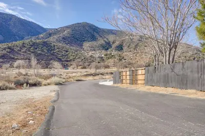 an empty road with a fence and mountains in the background at Mountain Views Minimalist California Studio in Frazier Park